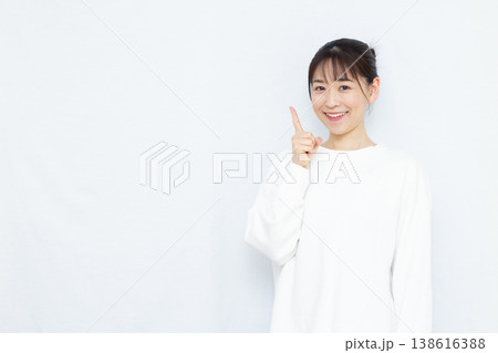 人差し指を立てる女性 138616388