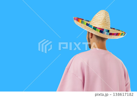 Cinco de Mayo, Young man stands with his back turned, wearing sombrero 138617182