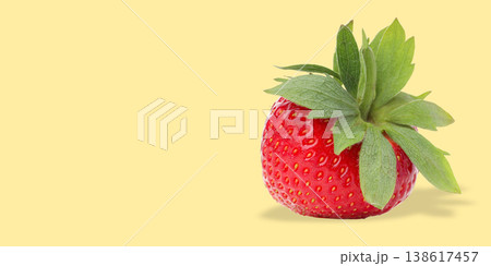 Bright red strawberry with green leaves rests on surface Bright red strawberry with green leaves rests on surface 138617457