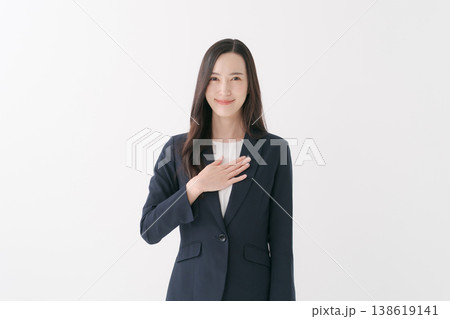 胸に手を当てる笑顔のビジネスウーマン 胸に手を当てる笑顔のビジネスウーマン 138619141