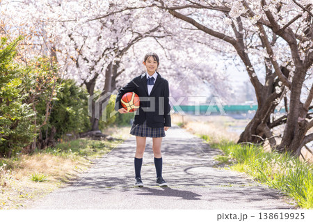 桜の下でバスケットボールを持つ制服の女子中学生 138619925