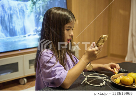 テーブルでみかんを食べる女の子 テーブルでみかんを食べる女の子 138619969