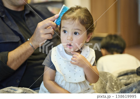 ブラシで幼児の髪をとかす父親 138619995