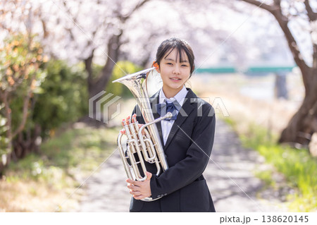 桜の中で金管楽器を持つ女子生徒 138620145