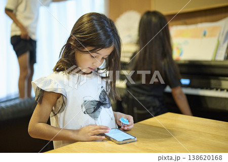 テーブルでスマホを操作する女の子 138620168