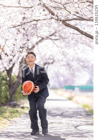 満開の桜の下でバスケットボールをする男子学生 138620295