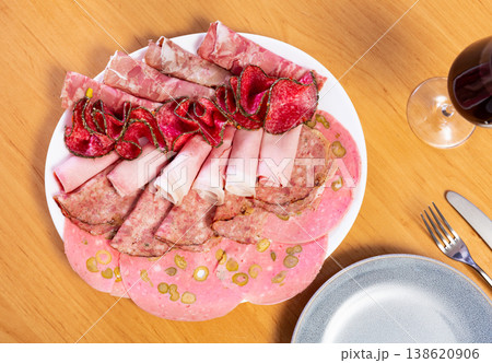 Slices of butifarra and smoked sausage dished up in a service plate on laid restaurant table Slices of butifarra and smoked sausage dished up in a service plate on laid restaurant table 138620906
