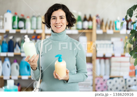 Adult woman buyer chooses liquid soap in store Adult woman buyer chooses liquid soap in store 138620916