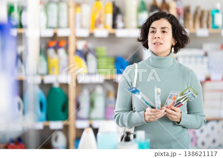 Middle-aged woman choosing toothbrush in retail store 138621117