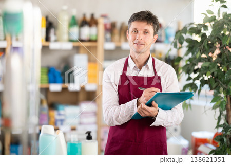 Middle-aged marketer taking record of inventory in household store 138621351
