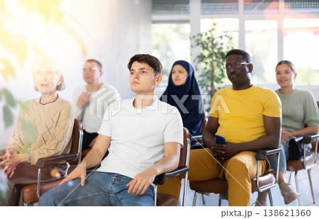 Guy teenager listens to lecture while sitting on chair Guy teenager listens to lecture while sitting on chair 138621360