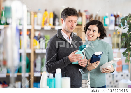 Couple man and woman choosing cleaning spray in store Couple man and woman choosing cleaning spray in store 138621418
