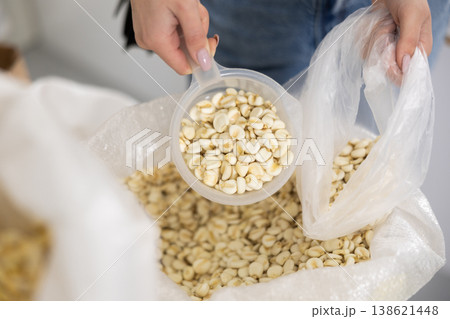 Woman's hand scooping corn kernels from bag in store Woman's hand scooping corn kernels from bag in store 138621448
