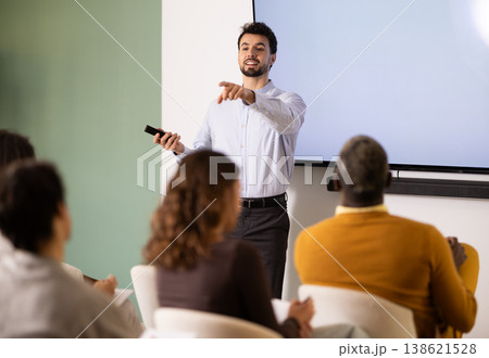 Group of students listening to coach speaking on topic during educational session 138621528