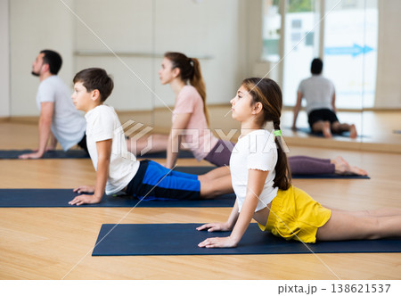 Family of four practicing yoga at gym 138621537