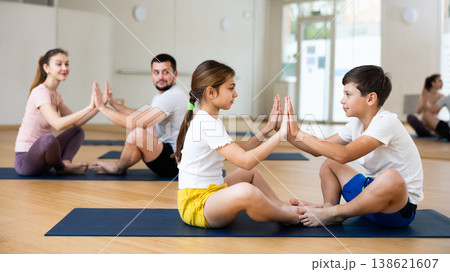 Siblings practicing partner yoga poses at gym 138621607