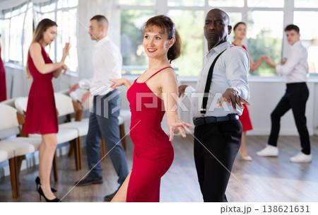 African American man and woman in red dancing twist in studio African American man and woman in red dancing twist in studio 138621631