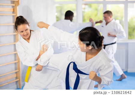Karate with two female athletes practicing, training and sparring in fight class. Healthy, fit and active women in uniform learning self defense for safety 138621642