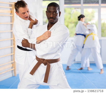 Middle-aged male judo practitioner engaged in wrestling in sports hall Middle-aged male judo practitioner engaged in wrestling in sports hall 138621718