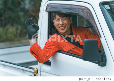 軽トラに乗るつなぎ姿の男性 138621775