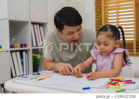Caption/Description: father and child girl drawing and painting with colorful oil pastels on paper Caption/Description: father and child girl drawing and painting with colorful oil pastels on paper 138622358