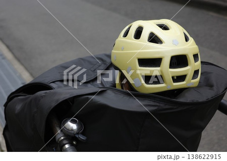 カバーを付けた子乗せ自転車の前かごチャイルドシートに乗ってヘルメットを被る子供の後ろ姿 カバーを付けた子乗せ自転車の前かごチャイルドシートに乗ってヘルメットを被る子供の後ろ姿 138622915