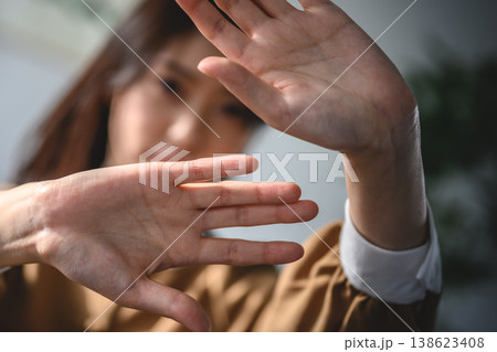 手をかざして拒否する女性 138623408