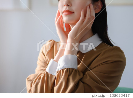 顔に手を当てる女性のクローズアップ 顔に手を当てる女性のクローズアップ 138623417