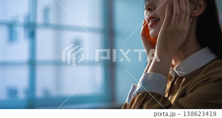 窓辺で顔に手を当てる女性のクローズアップ 窓辺で顔に手を当てる女性のクローズアップ 138623419