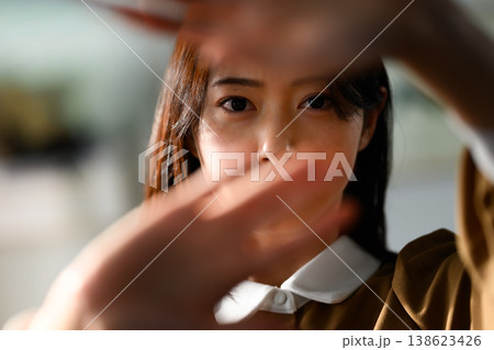 顔の前で手をかざす女性 顔の前で手をかざす女性 138623426