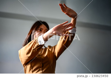 両手を広げて何かを防ぐ女性 138623450