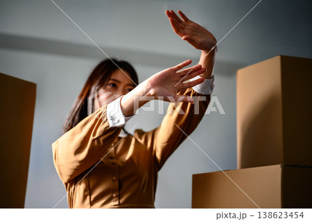 両手を広げて何かを防ぐ女性 138623454