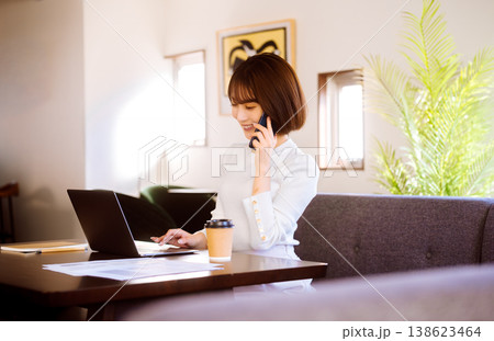 女性がカフェで電話とPC作業 女性がカフェで電話とPC作業 138623464
