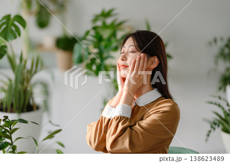 女性が目を閉じて頬に手を当てリラックスする様子 138623489