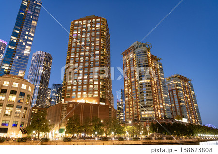 Business skyscraper at night. Skyscraper in city downtown. City architecture. Office building in business district. Modern glass building. Chicago night city. Night cityscape of Chicago skyscraper Business skyscraper at night. Skyscraper in city downtown. City architecture. Office building in business district. Modern glass building. Chicago night city. Night cityscape of Chicago skyscraper 138623808