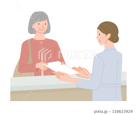 病院の受付で書類を渡すシニア女性と女性スタッフ 138623929
