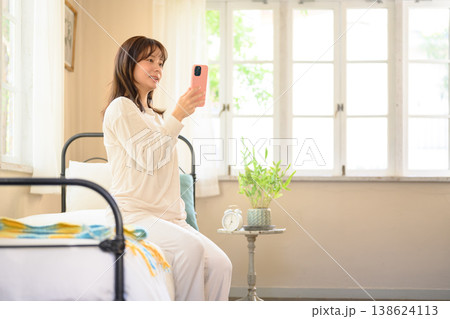 ベッドでスマホを見る女性 ベッドでスマホを見る女性 138624113