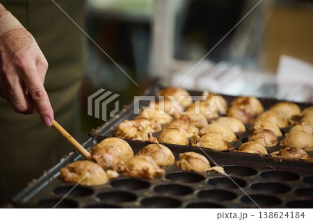 たこ焼きを焼く手元のクローズアップ たこ焼きを焼く手元のクローズアップ 138624184