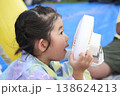 ハンディファンで涼む浴衣姿の女の子の横顔 138624213