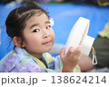 ハンディファンを持ってカメラを見る浴衣姿の女の子 138624214