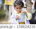 屋台の唐揚げを食べる浴衣姿の女の子 138624216