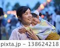 夏祭りで妹を抱く浴衣姿の母親 138624218