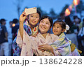 夏祭りでスマホで記念撮影する浴衣姿の家族 138624228