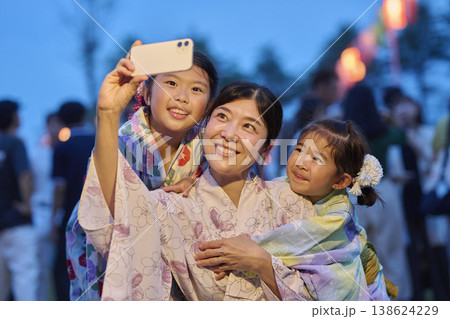 夏祭りの思い出にスマホで写真を撮る母と娘たち 夏祭りの思い出にスマホで写真を撮る母と娘たち 138624229