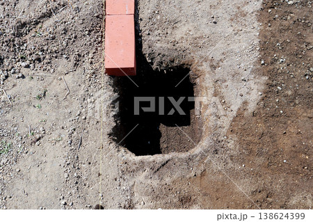 墨糸を張って「フェンスブロック300型」を埋める為の穴を掘る 138624399