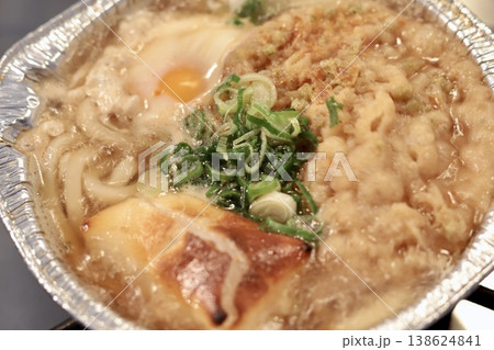 ガスにかけて沸騰しているアルミ鍋入りレトルトの天ぷら鍋焼きうどん 138624841