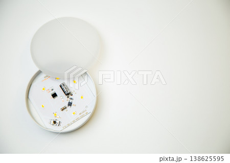 A small open light bulb with microcircuits and light elements inside lies on the side on a white background with space for text. Lighting concept, LED lamps. High quality photo  138625595
