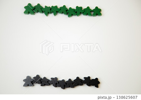 On a white background, there are green and black wooden figures of men, divided into two teams at the top and bottom with space for text. The concept of team competitions, community groups, people 138625607