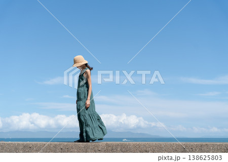 青空の下で帽子をかぶった女性 138625803
