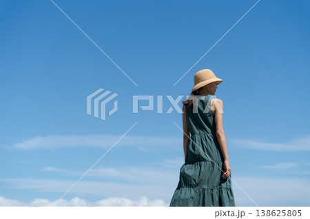 青空の下で帽子をかぶった女性 138625805